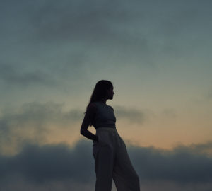 Woman standing in front of sunset