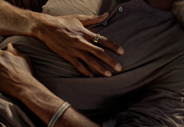 Man sleeping with hands on chest wearing an Oura Ring. Sleep Apnea, Defined — And How to Treat It.