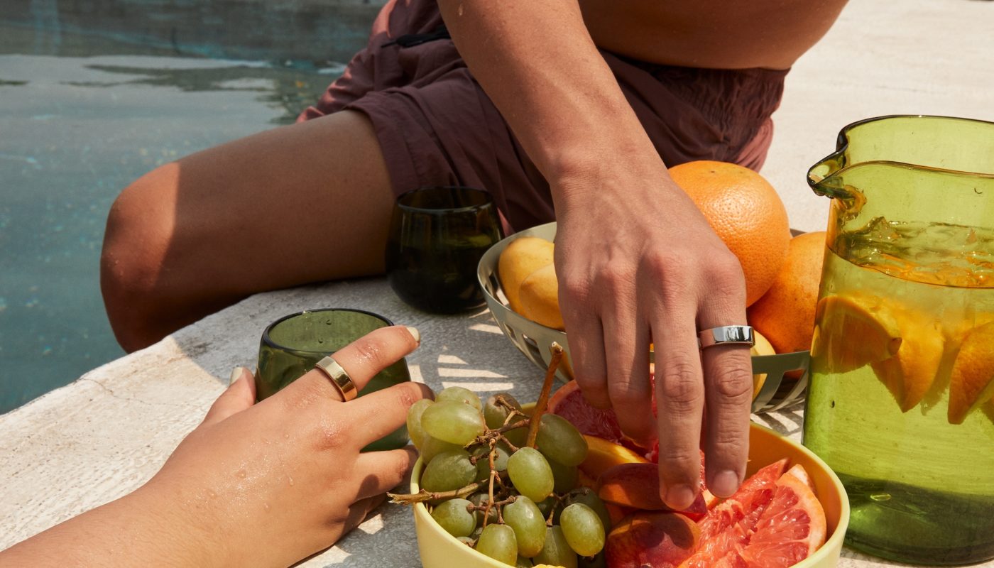 Oura Members Sitting by Pool Eating Fruit