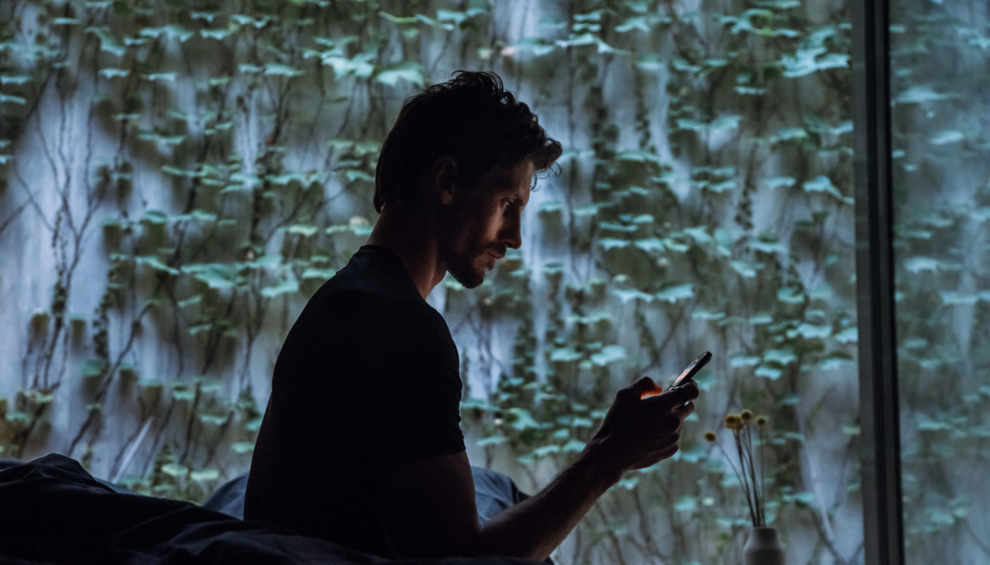 A man looking at his phone in the middle of the night