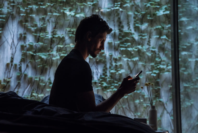 A man looking at his phone in the middle of the night