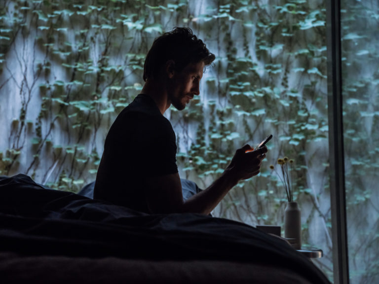 A man looking at his phone in the middle of the night
