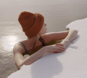 Woman sitting in ice bath wearing Oura Ring