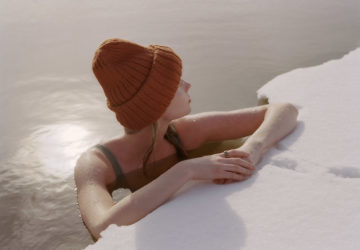Woman sitting in ice bath wearing Oura Ring