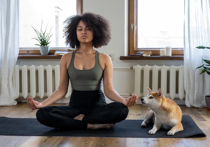Guided Meditations By Oura Ring: woman meditation on yoga mat with dog