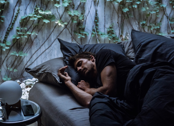 Man sleeping in dark bedroom | Oura Ring