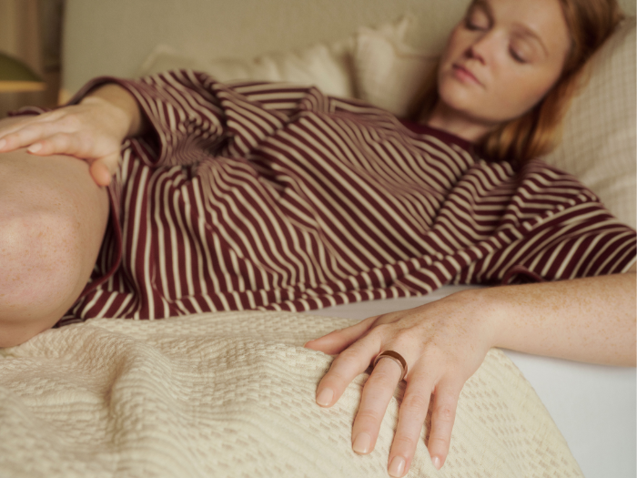 A woman taking a nap with her Oura Ring