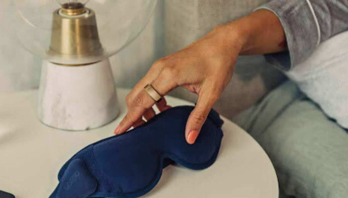 Person wearing Oura Ring reaching for sleep eye mask