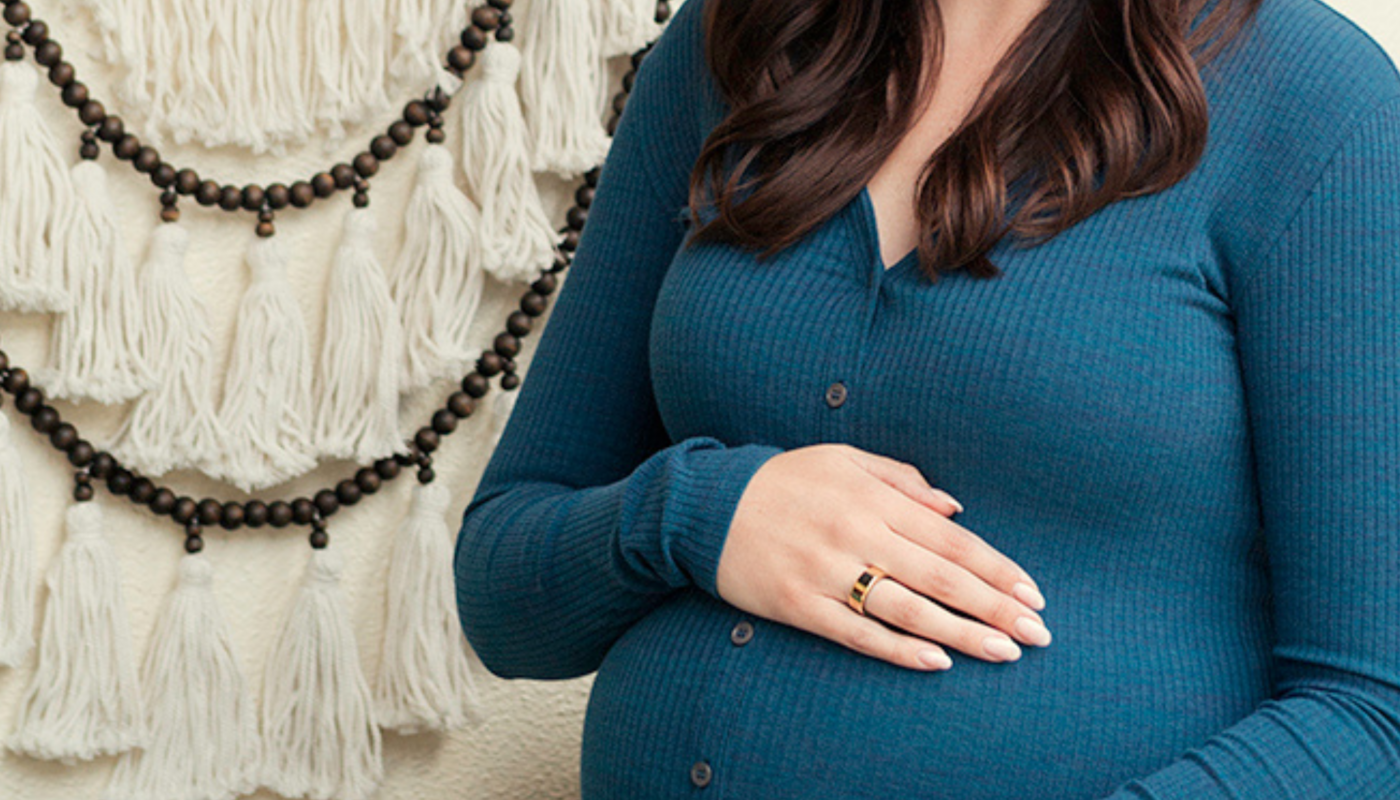 Pregnant woman in blue dress wearing Oura Ring