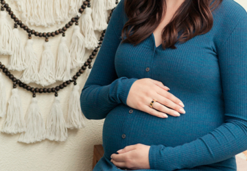 Pregnant woman in blue dress wearing Oura Ring