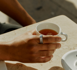 Person drinking tea wearing Oura Ring 4