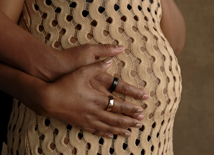 Pregnant woman wearing Oura Ring holding her belly