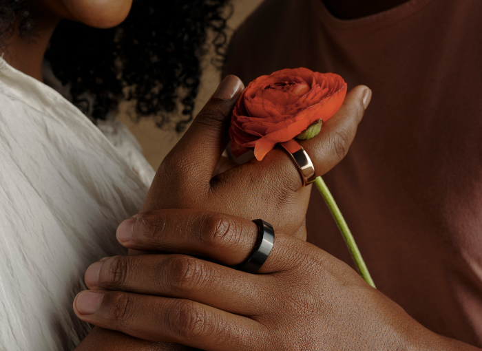 Two people wearing Oura Ring holding a rose