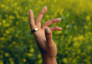 Woman wearing Oura Ring in a flower field