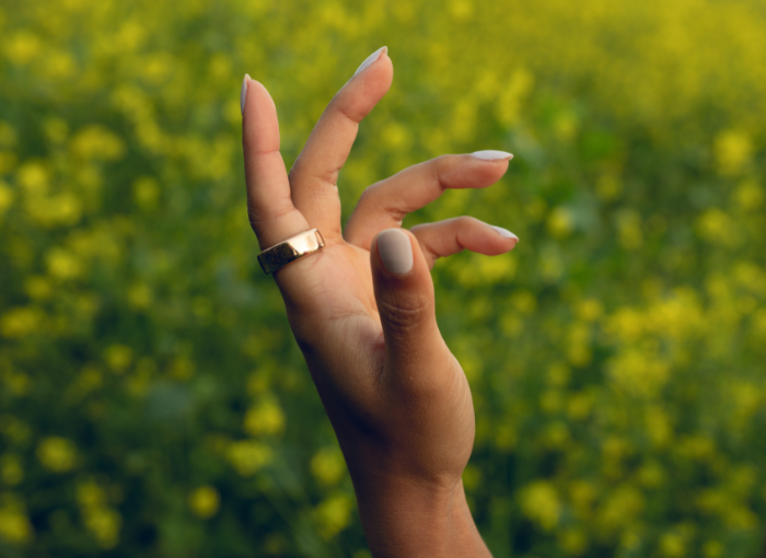 Woman wearing Oura Ring in a flower field