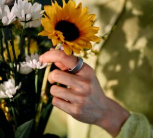 Woman picking a sunflower wearing Oura Ring 4