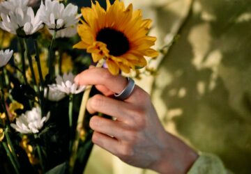 Woman picking a sunflower wearing Oura Ring 4