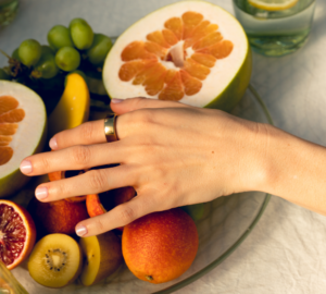 Woman wearing gold Oura Ring with a fruit bowl