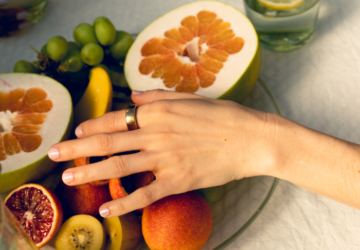 Woman wearing gold Oura Ring with a fruit bowl