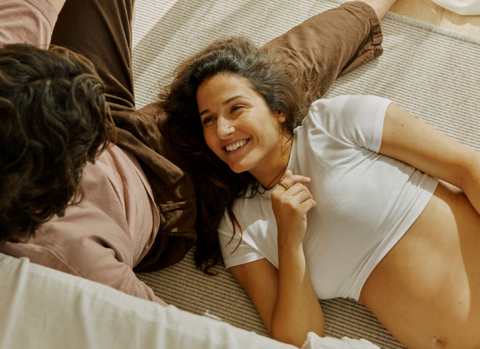 Woman and man in bed wearing Oura Ring