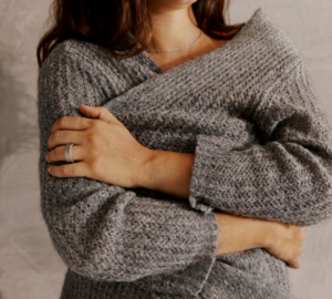 Woman in grey sweater wearing Oura Ring 4