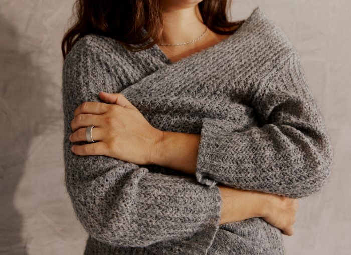 Woman in grey sweater wearing Oura Ring 4