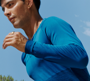 Man wearing blue shirt running with Oura Ring