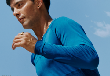 Man wearing blue shirt running with Oura Ring