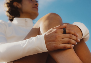 Woman sitting down wearing Oura Ring