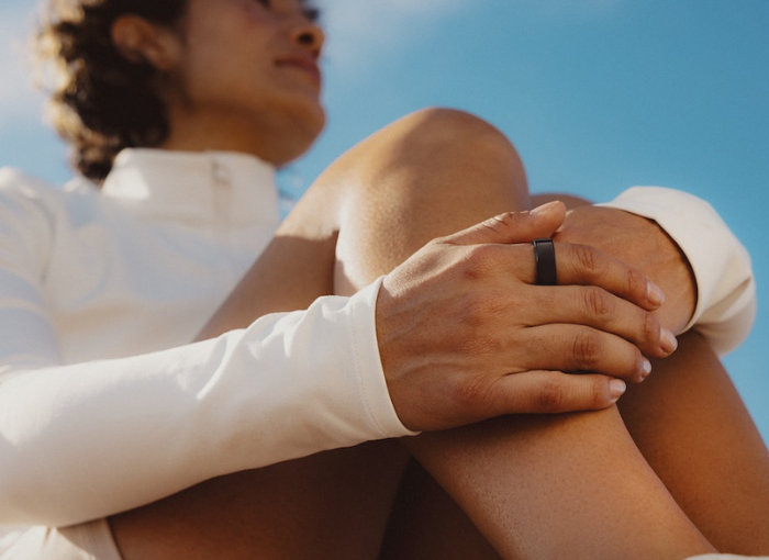 Woman sitting down wearing Oura Ring