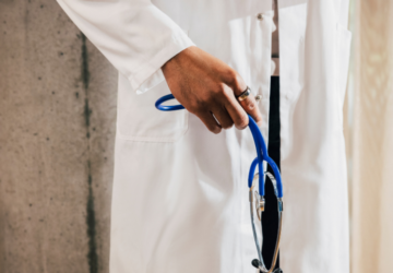 Doctor in white coat wearing Oura Ring