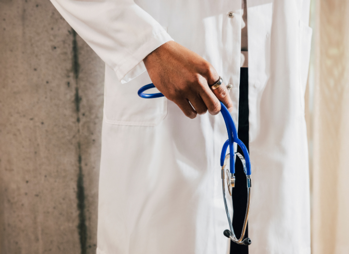 Doctor in white coat wearing Oura Ring