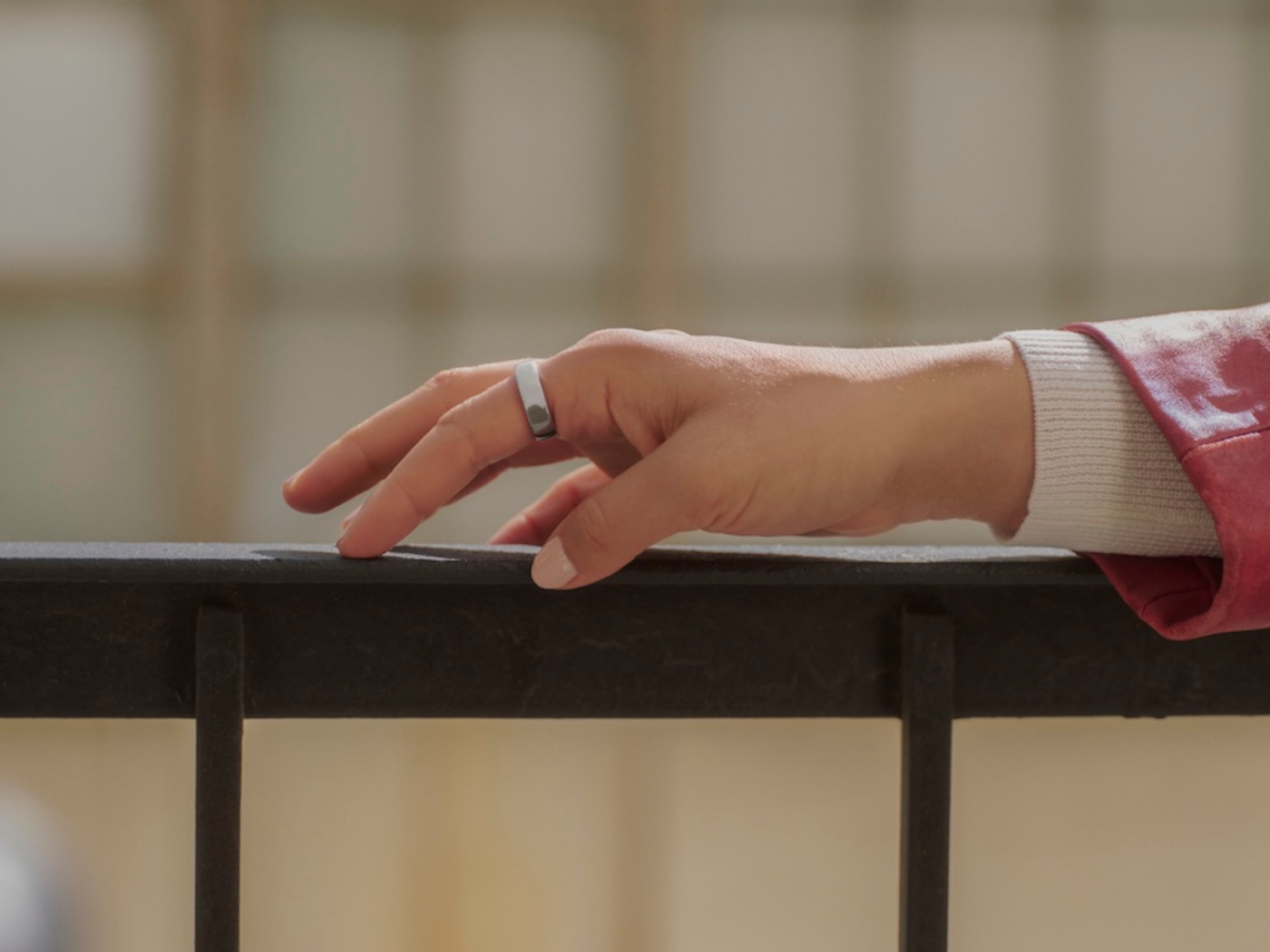 Woman wearing Oura Ring 5 with hand on railing