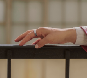 Woman wearing Oura Ring 5 with hand on railing