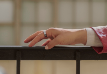 Woman wearing Oura Ring 5 with hand on railing