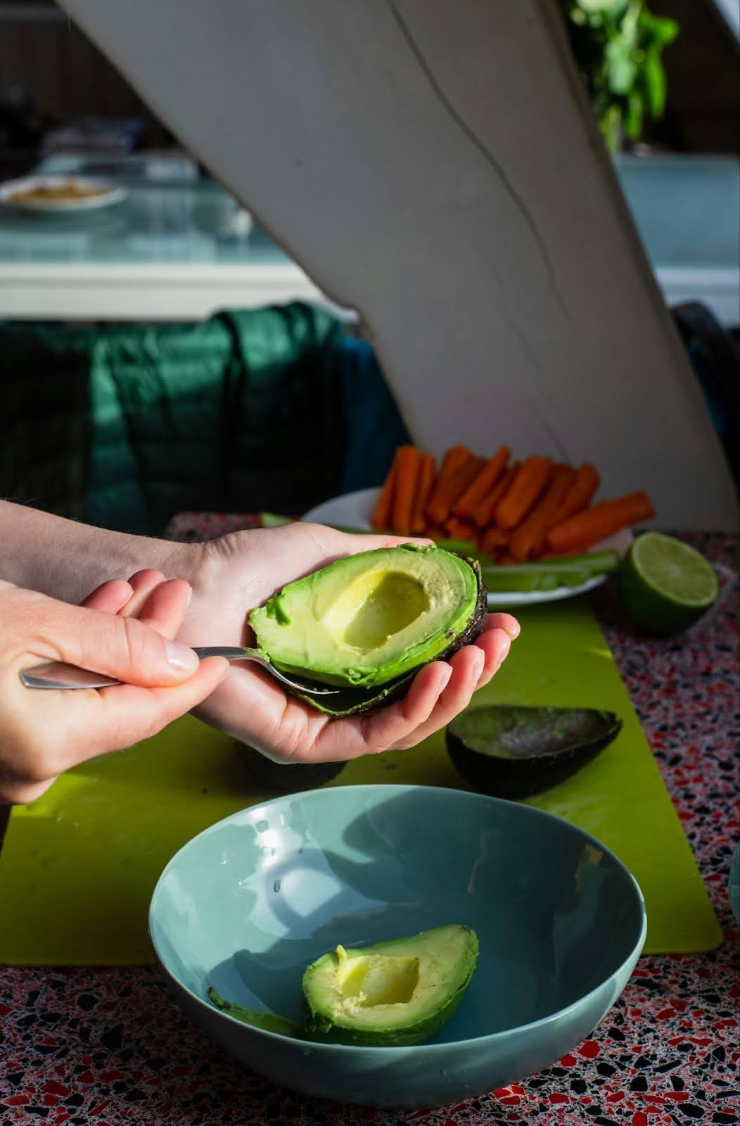 Scooping avocado on plate