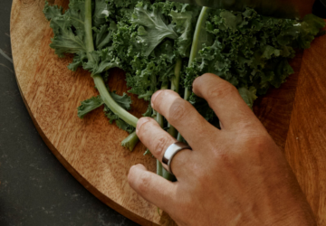 Man wearing Oura Ring chopping kale