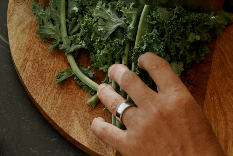 Man wearing Oura Ring chopping kale