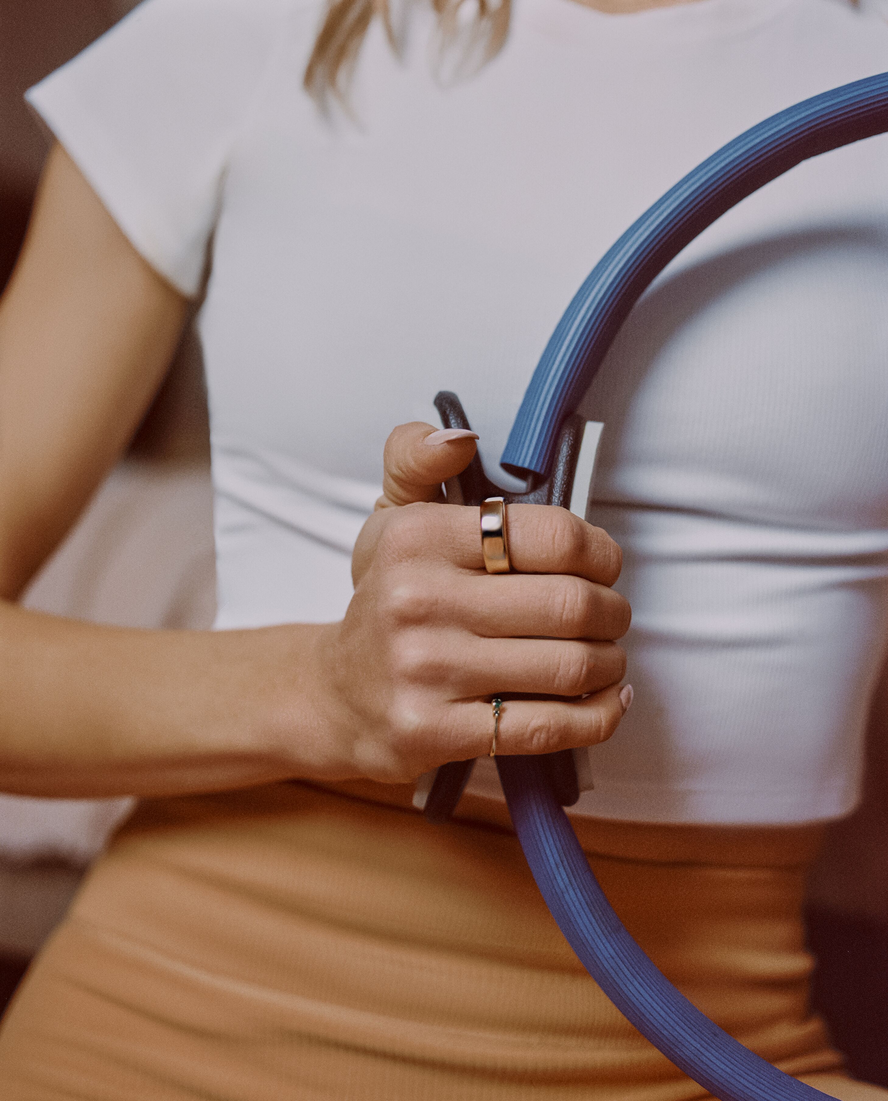 Woman wearing Oura Ring holding Pilates circle