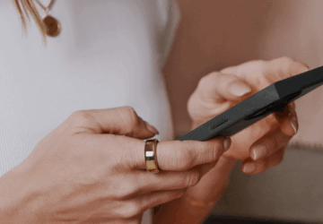 Woman looking at phone wearing Oura Ring