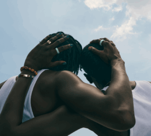 Two men embracing wearing Oura Ring 4 Ceramic in Tide