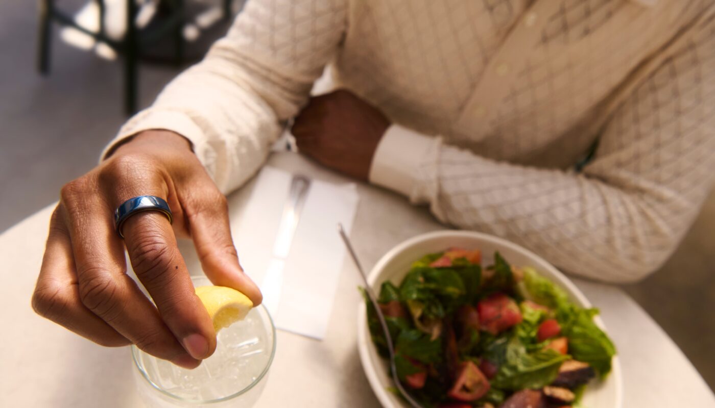 Person eating a salad wearing Oura Ring 4 Ceramic in Midnight