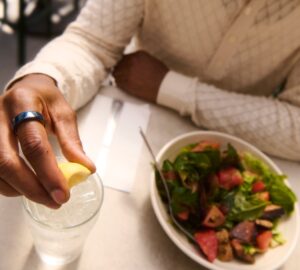 Person eating a salad wearing Oura Ring 4 Ceramic in Midnight
