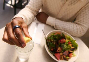 Person eating a salad wearing Oura Ring 4 Ceramic in Midnight