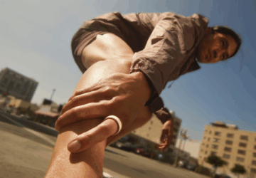 Man stretching wearing Oura Ring 4 Ceramic in Cloud