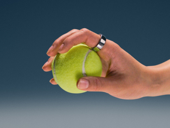 Hand wearing Oura Ring 4 holding a tennis ball