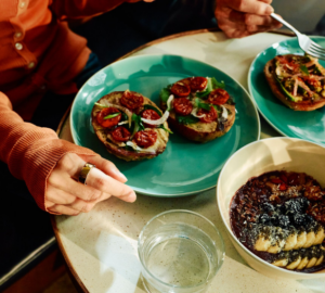 Person wearing Oura Ring eating an open-faced bagel