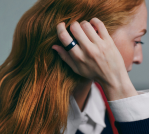 Woman with red hair wearing Oura Ring 4 Ceramic in Midnight