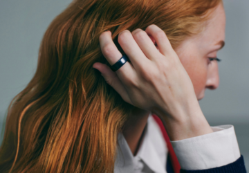 Woman with red hair wearing Oura Ring 4 Ceramic in Midnight