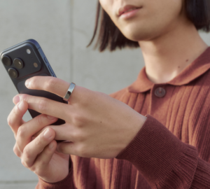 Woman wearing Oura Ring and looking at phone screen